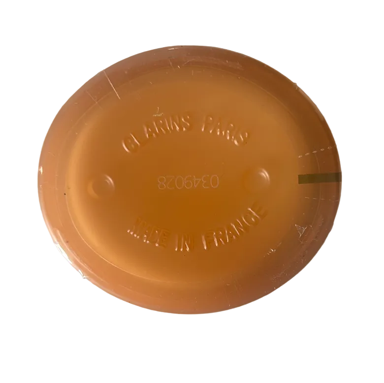 Orange plastic lid with 'Clarins Paris' branding on a white background